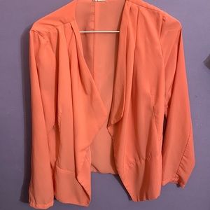 A large, tangerine color, spring like thin blazer for women.